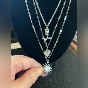 3 different necklaces one with a sun, one with heart rhinestones and rose